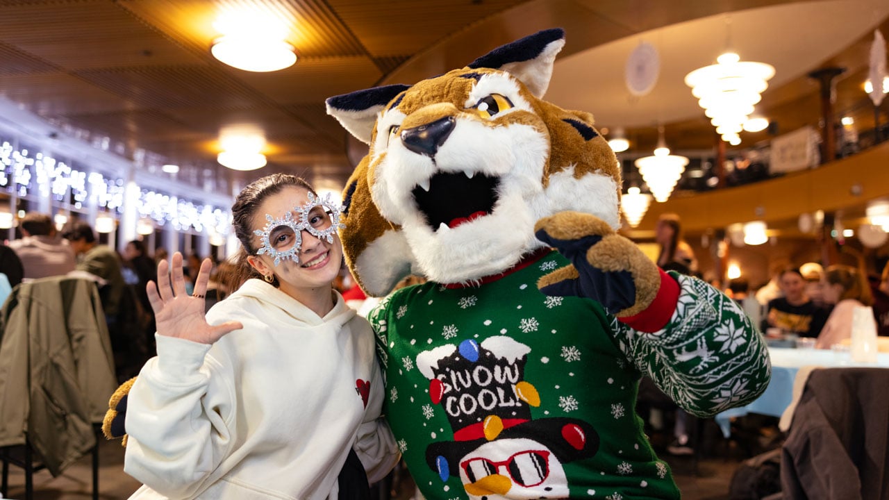 Boomer poses with student for picture, both dressed festively