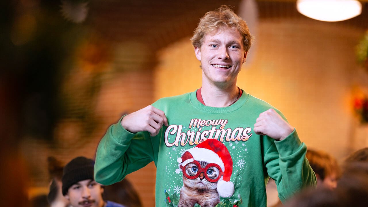 Student poses to show off his Christmas sweater