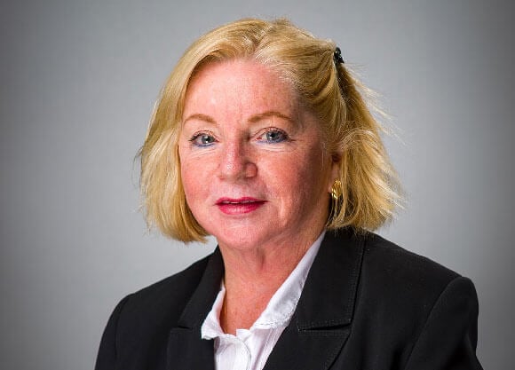 Headshot of Professor Margaret Goralski wearing a black blazer against a gray background.