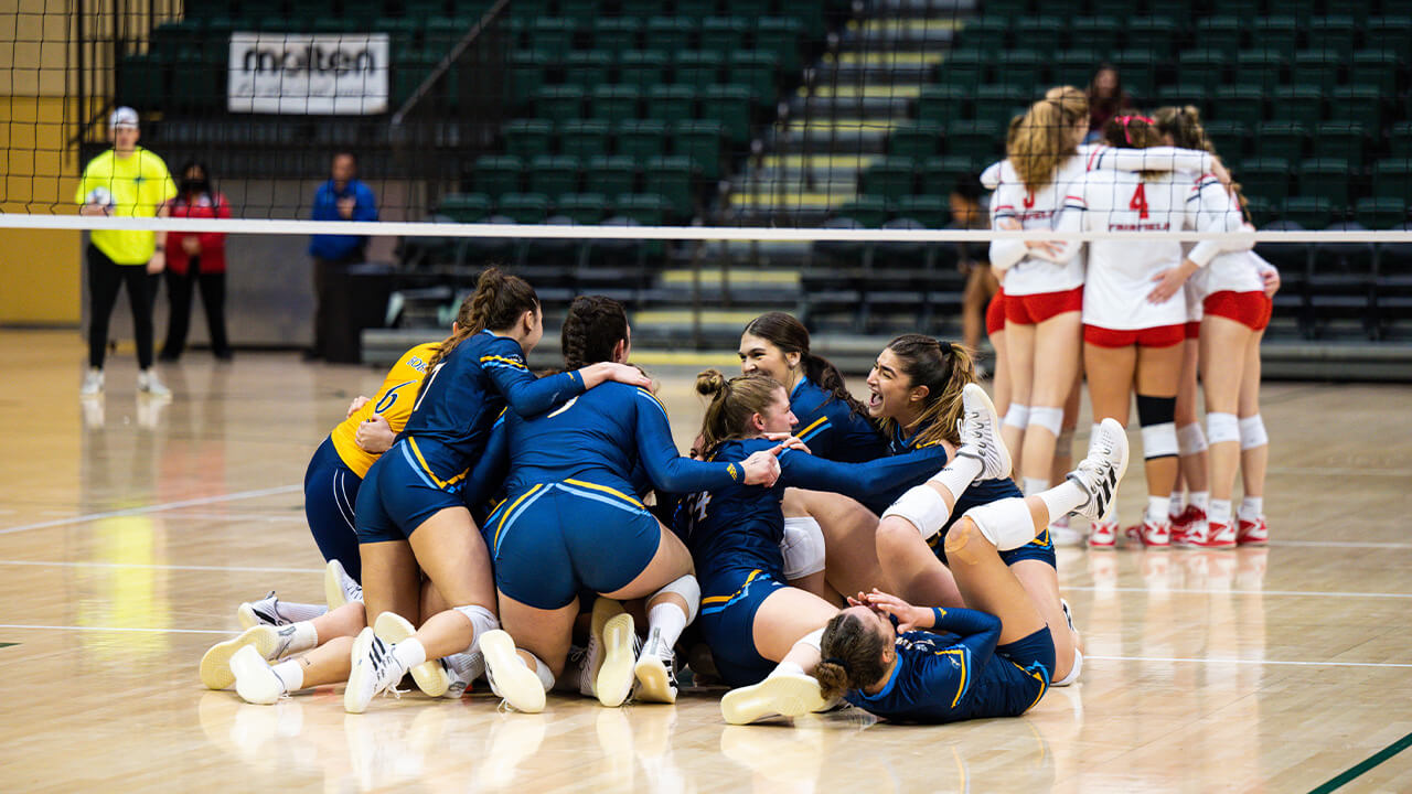 The team piles on top of eachother in excitement after winning the game.