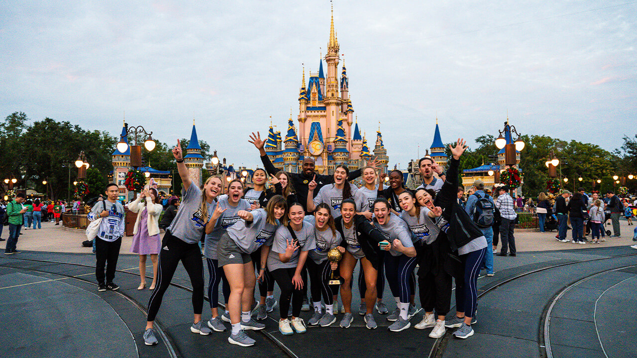 The team poses in front of the iconic castle in Disney World after winning the game.