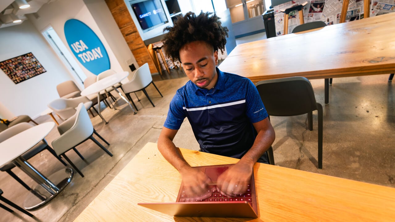 Toyloy Brown typing on a laptop in the USA Today offices