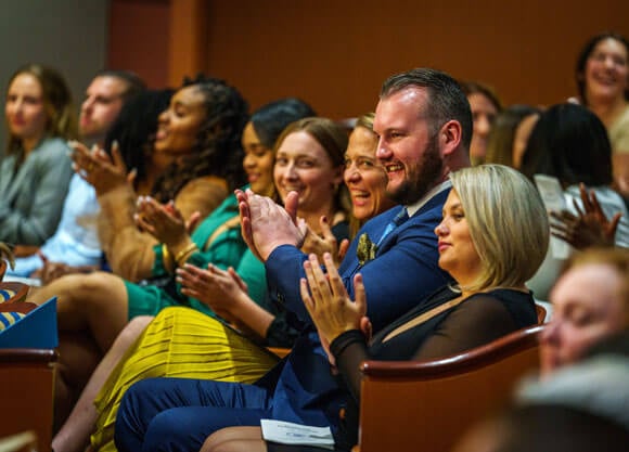 Nursing students applaud in audience at inaugural hybrid accelerated nursing pinning ceremony