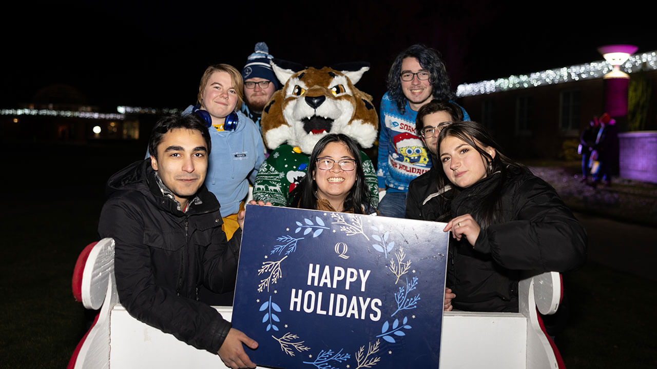 Students smiling in a sleigh with Boomer the Bobcat