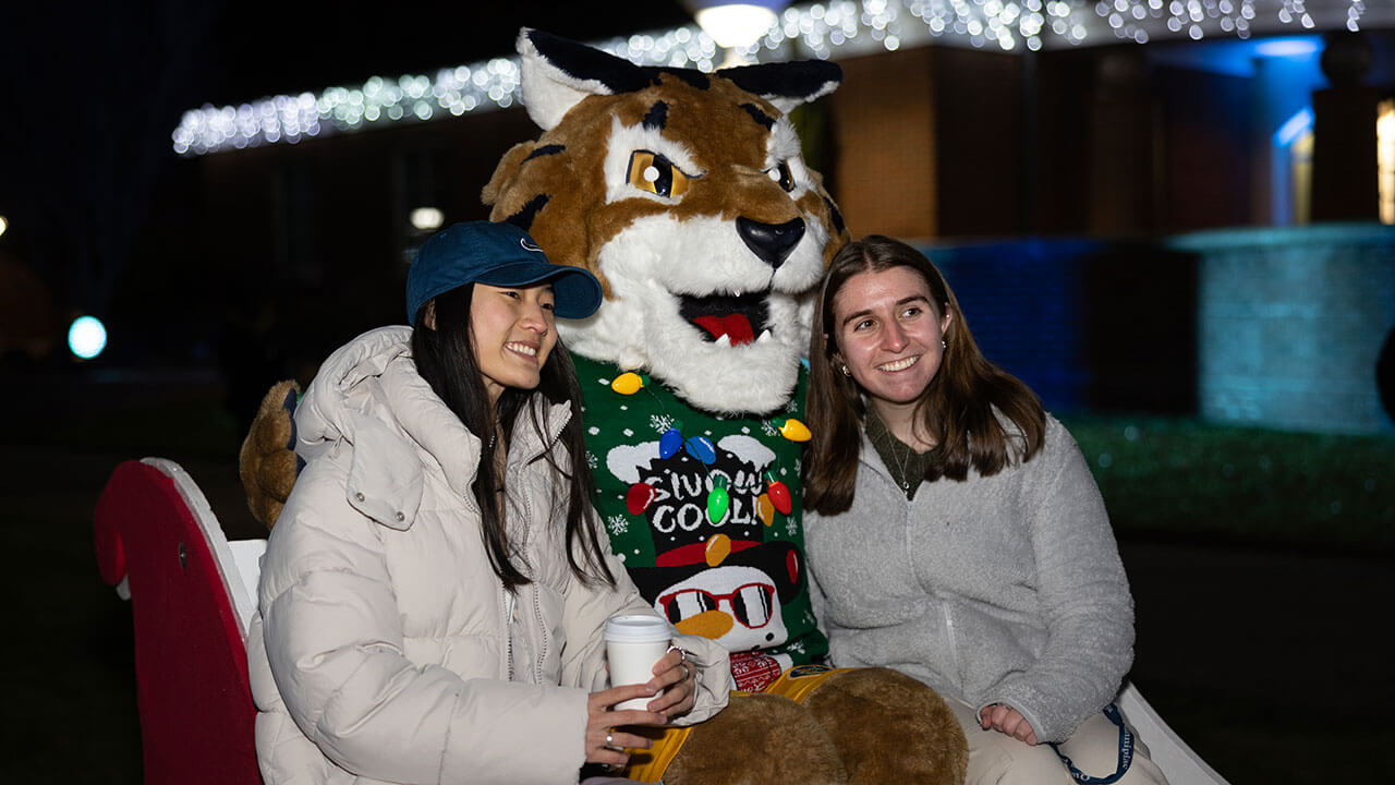 Students enjoying hot cocoa with boomer on a sleigh
