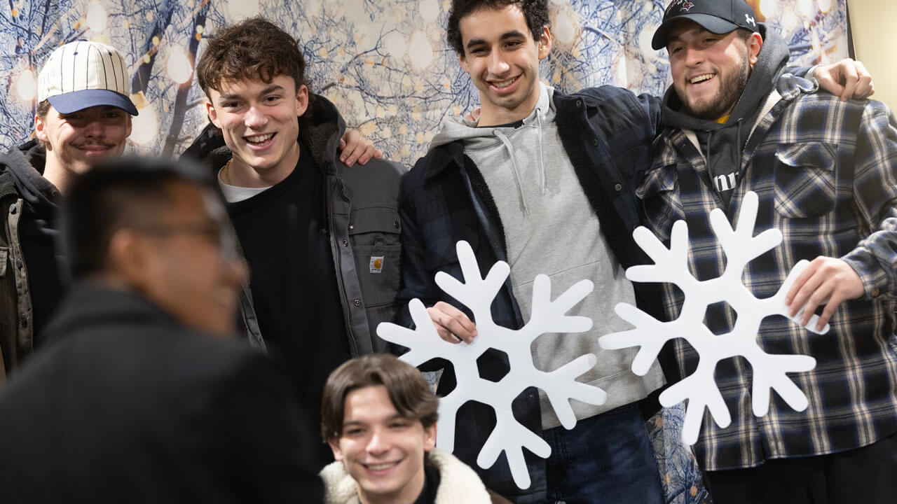 Students pose with snowflakes at undergraduate holiday dinner