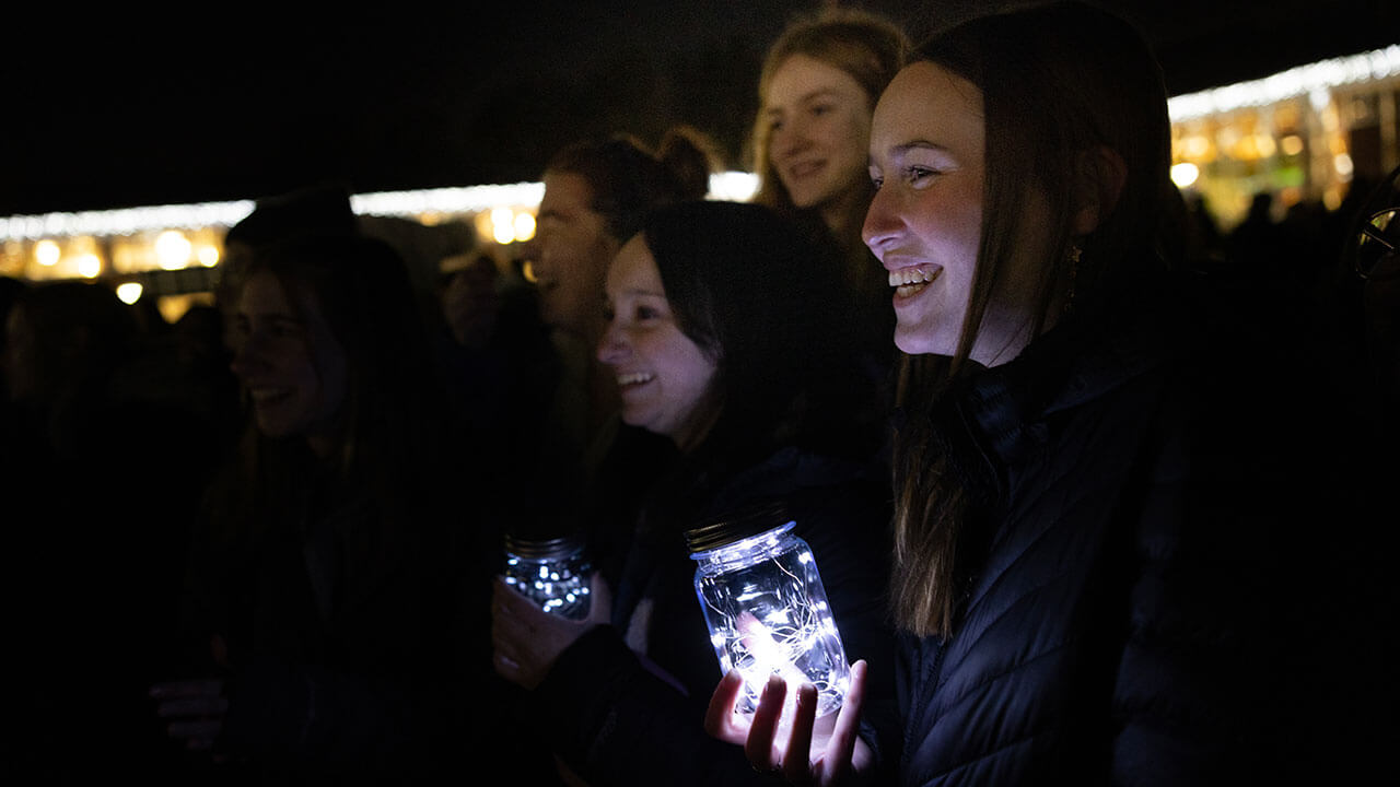 Students hold mason jars with fairy lights