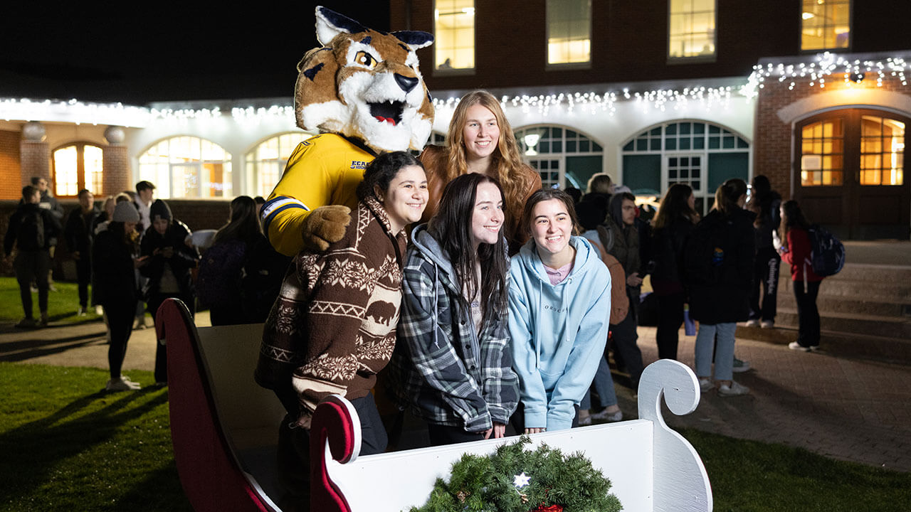 Students smile with Boomer for a photo