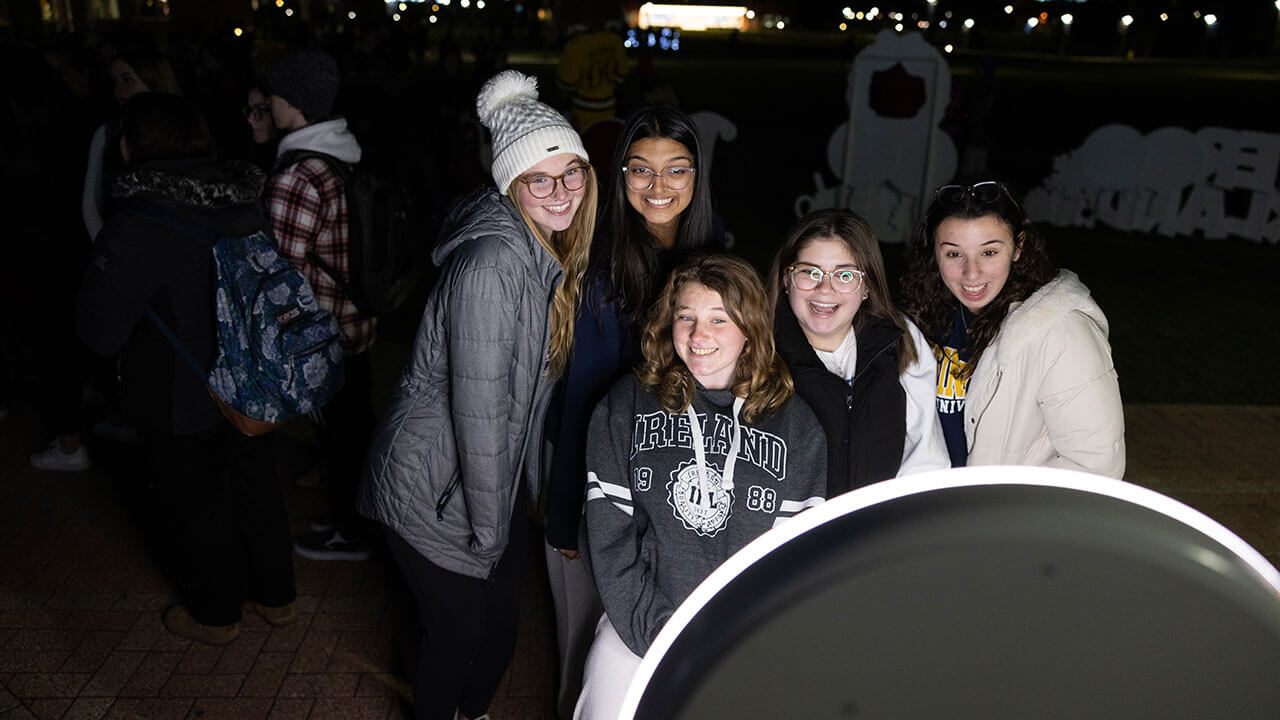 Students use the photo booth at the Quad lighting