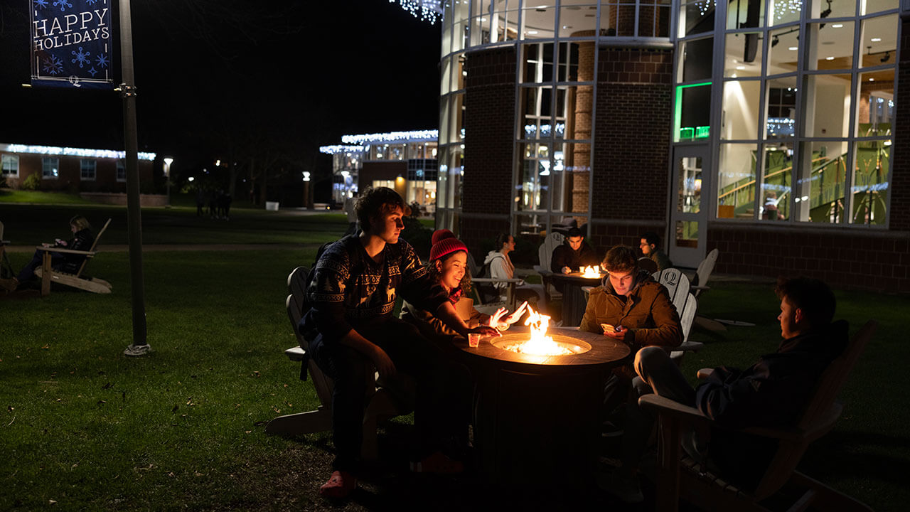 Students use the fire pits and warm up while hanging out with friends