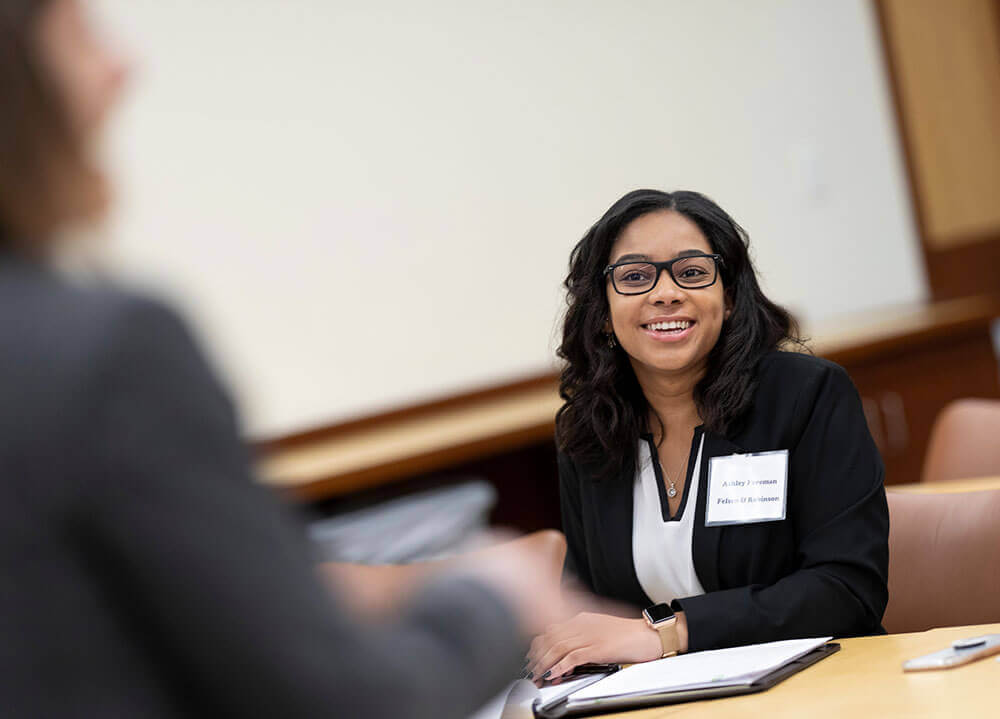 A School of Law student smiles in the audience during a workshop session