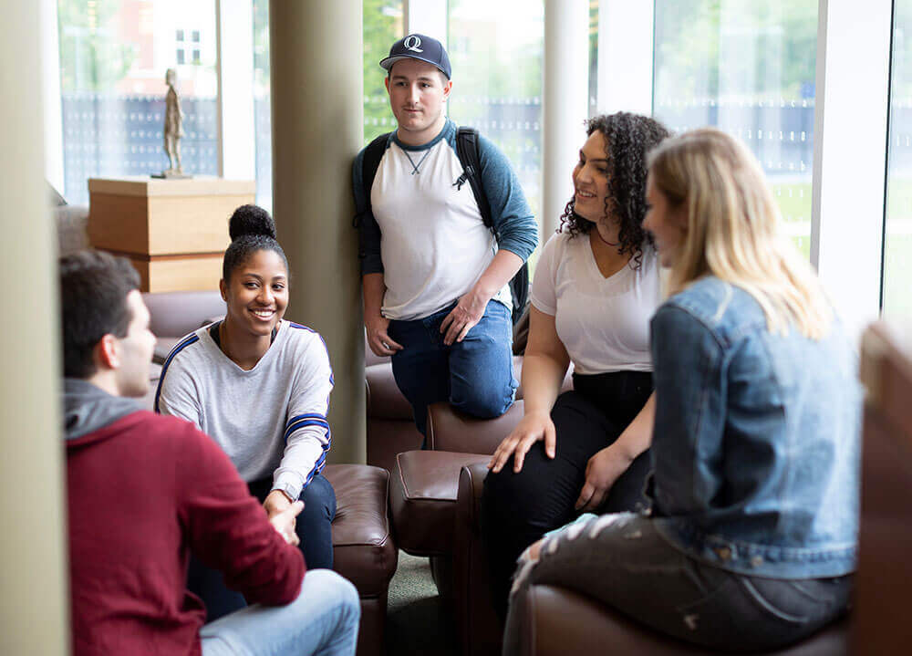 A group of Quinnipiac students engage in discussion in the Arnold Bernhard Library