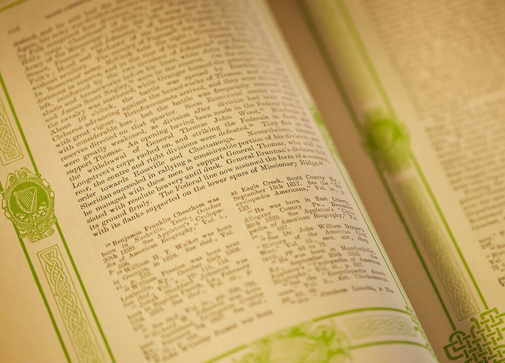 Close up shot of an old textbook with elaborate green Celtic designs bordering the text