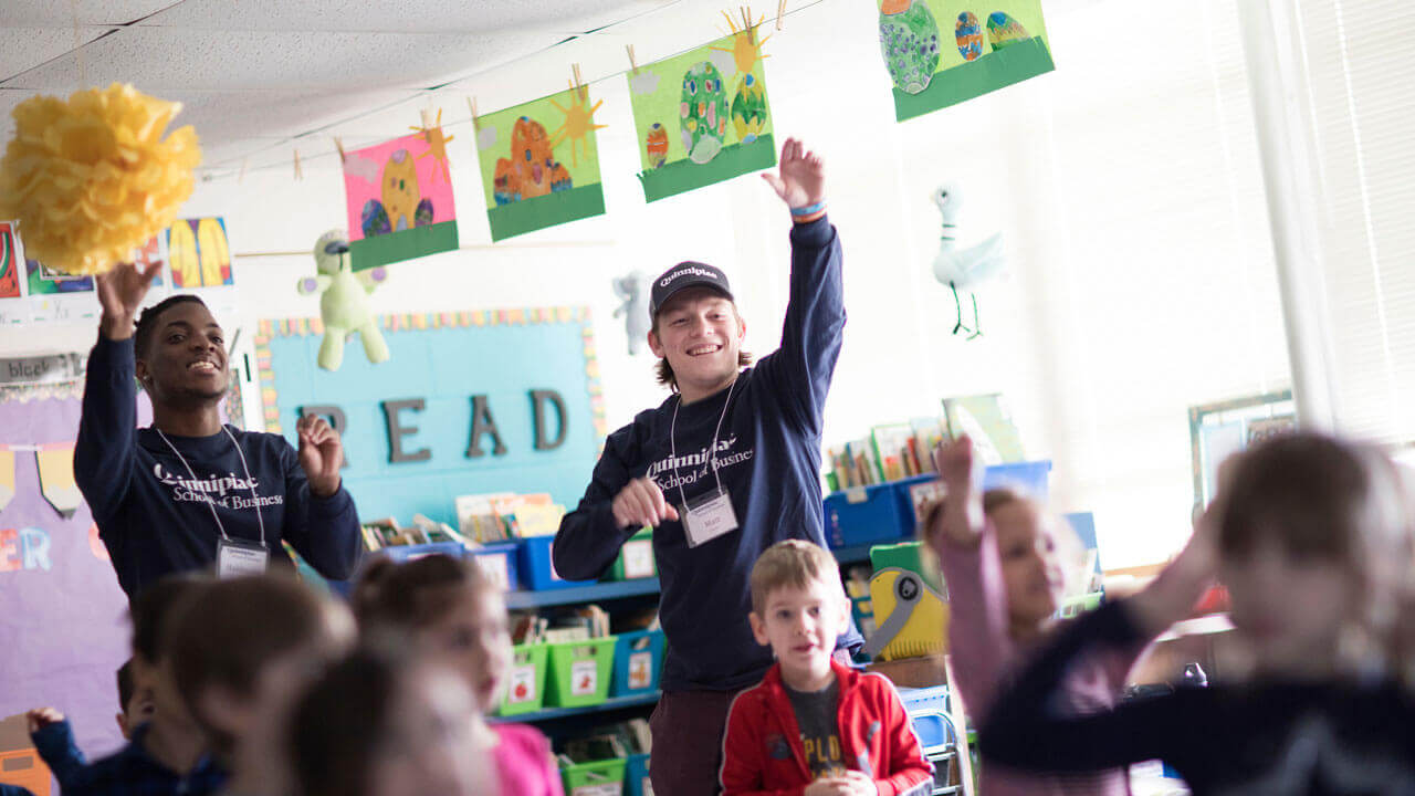 Quinnipiac School of Business students teach students about the world of business and entrepreneurship at Cook Hill Elementary School in Wallingford