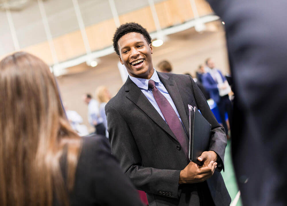 A student smiles during a career fair in the Recreation Center Courts on Quinnipiac’s Mount Carmel Campus