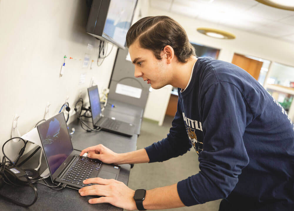 Student works on a loaner laptop at the technology center in the Arnold Bernhard Library on Quinnipiac’s Mount Carmel Campus