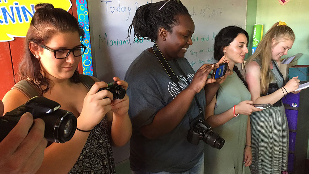 Journalism students inspect their photo cameras