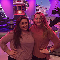 Two communications student smiling on set of Harry Connick Junior's talk show