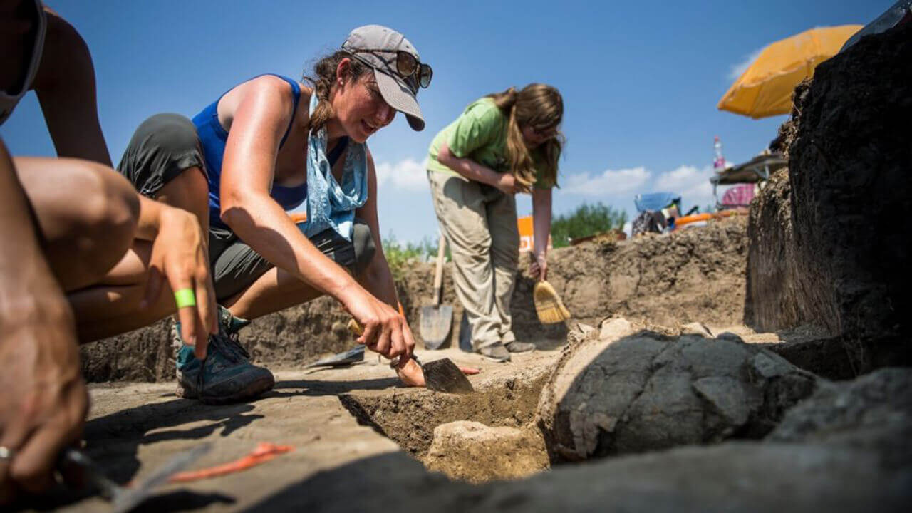 Julia Giblin digs in the dirt of an excavation site in Hungary.
