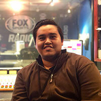 Headshot of media studies student Kevin Perez on-set at Fox Radio