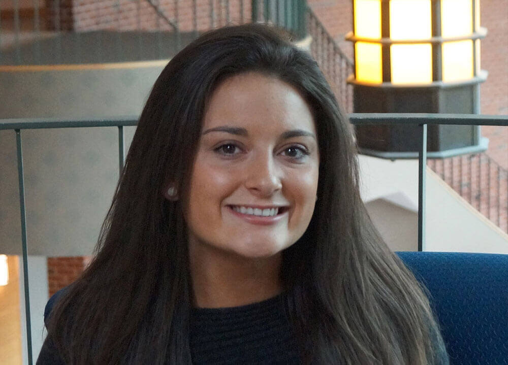 An advertising student smiles while sitting in the Center for Communications and Engineering