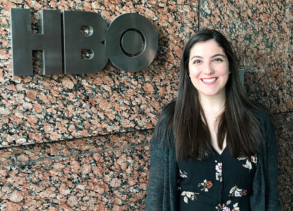 Communications alumni Katerina Randazzo poses next to the HBO sign outside of their headquarters