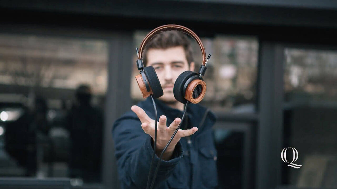 Image of alumni Jonathan Grado holding his hand out under levitating headphones, intro to video profile