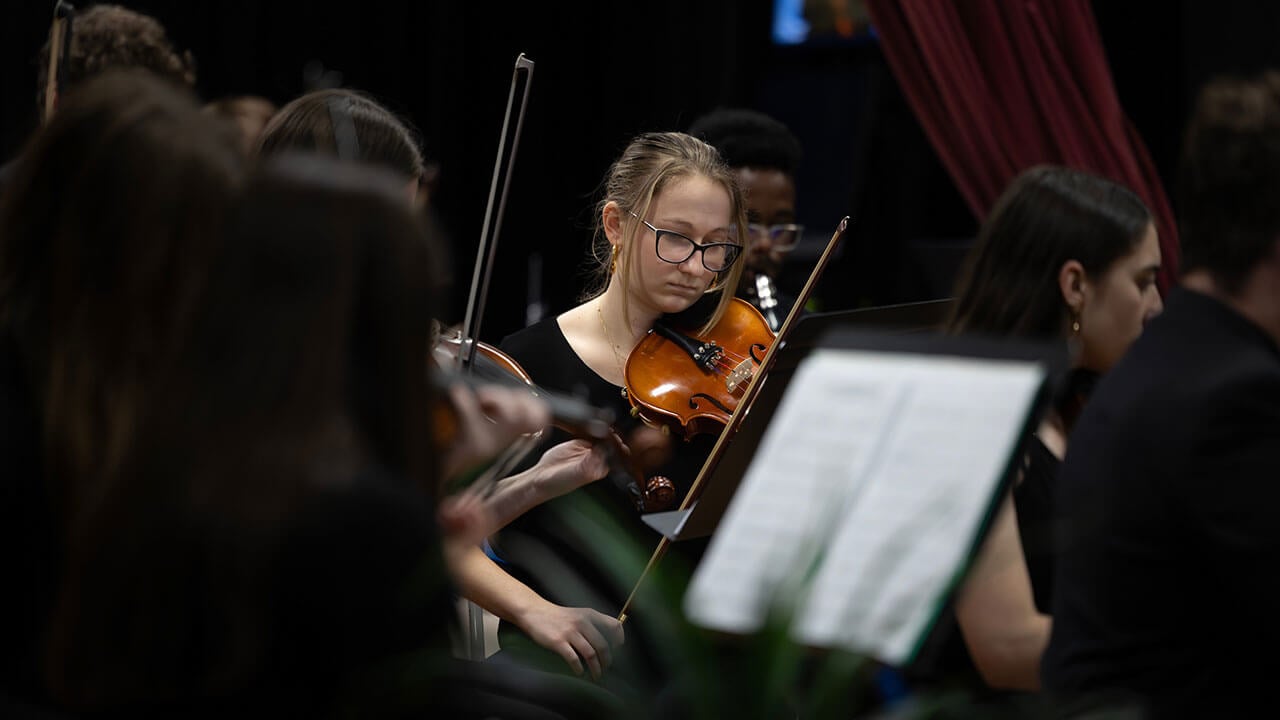 A student plays violin during their winter concert in Buckman Theater.