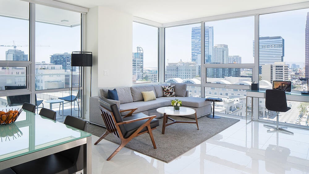 Interior shot of a living room and kitchen area in a Los Angeles apartment overlooking the city