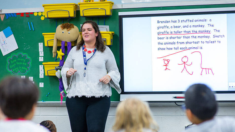 A School of Education student stands in front of an elementary class and teaches grammar
