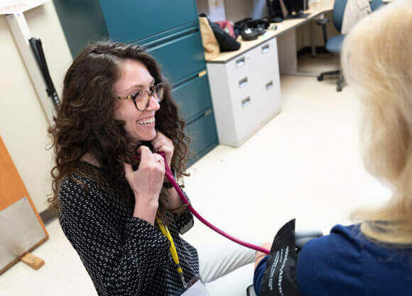 A medical student talks to a patient in a doctor's office