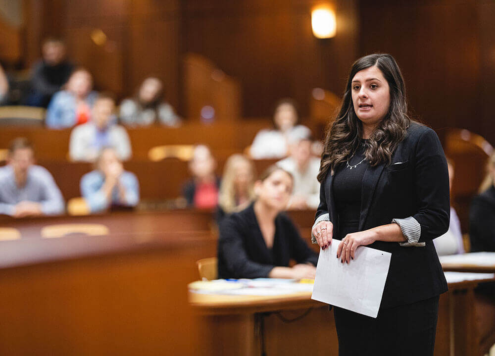 A law student acts as a prosecutor in a packed courtroom during a mock trial in the School of Law