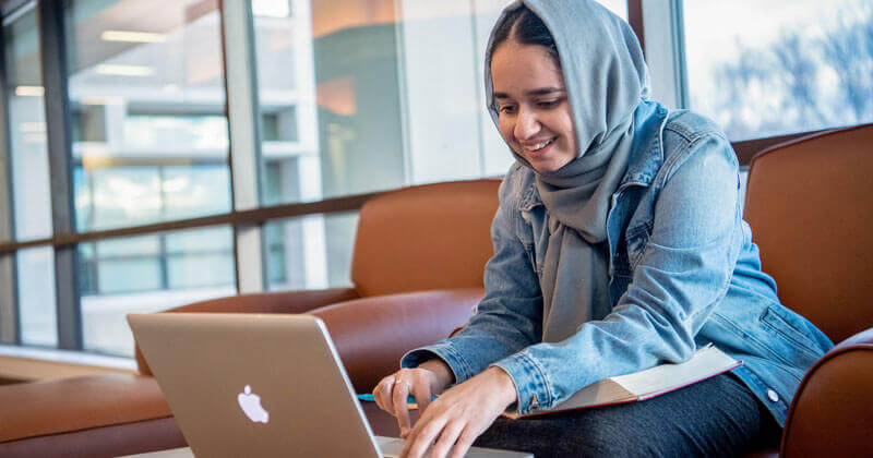 A law student uses her computer while in the Quinnipiac School of Law Center