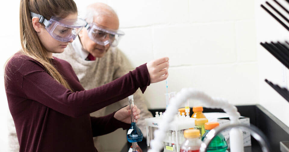 A pre-dental student and professor perform a lab experiment