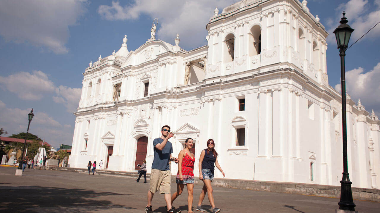 Three students visit the Cathedral of Leon in Parque Central in Leon, Nicaragua