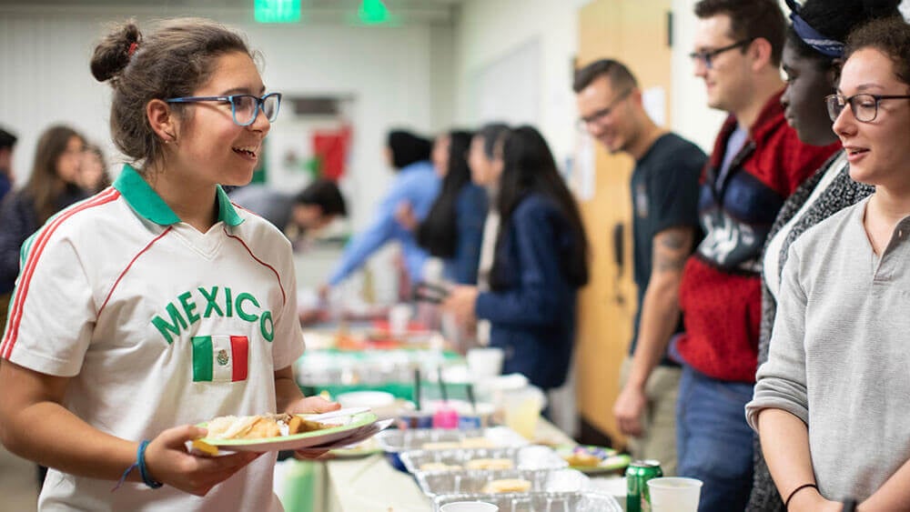 A student being served food at an international week event