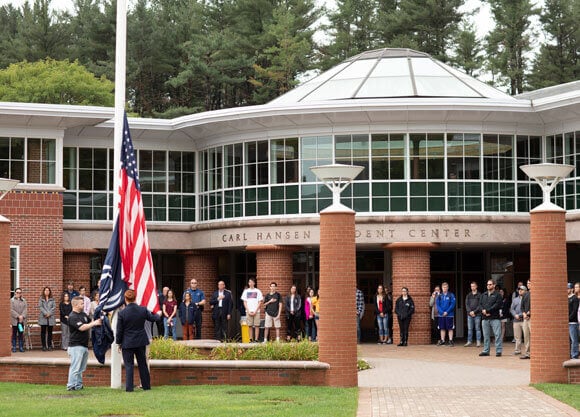 Student veterans raise the American flag during a ceremony