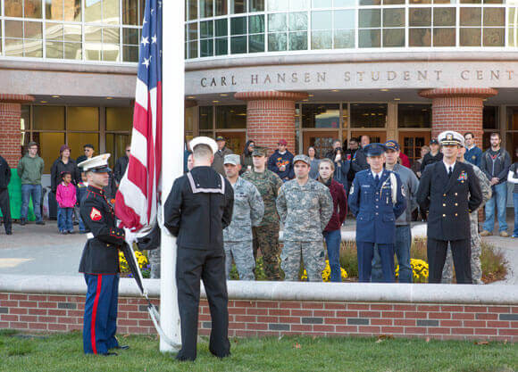 Student veterans raise the American flag during a ceremony