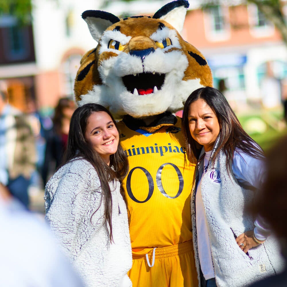 A student and her mother smile next to the Boomer mascot