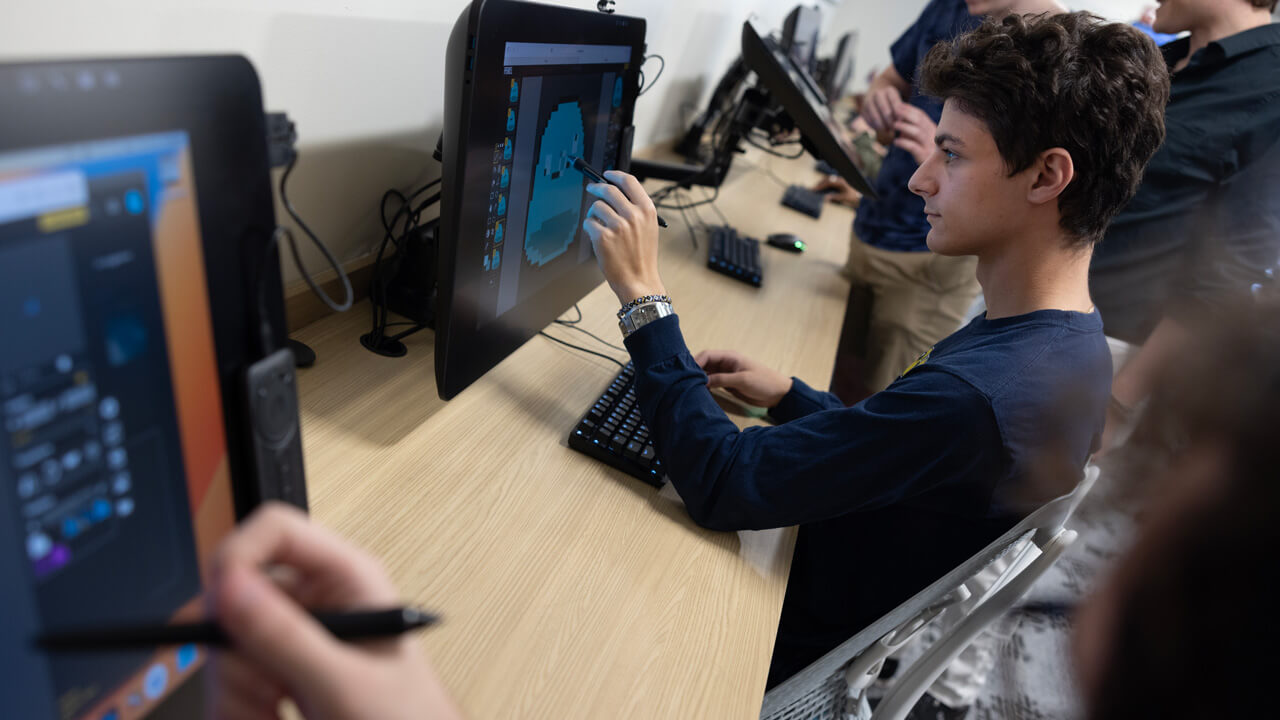 A male student drawing on a computer