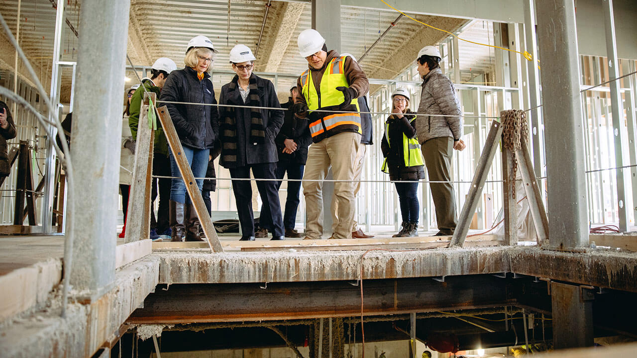 A group of QU staff look at construction in a building on the South Quad.