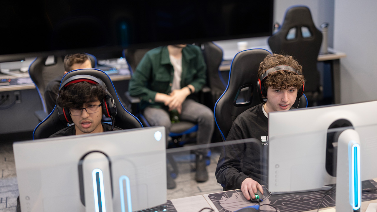 Two eSports athletes sitting at computers intensely participating.