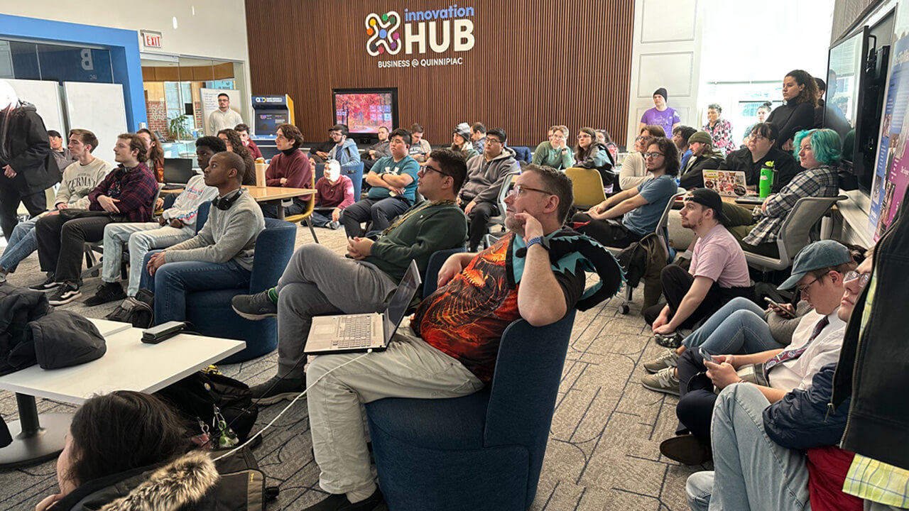 A large group/packed room all looking to something off screen intently