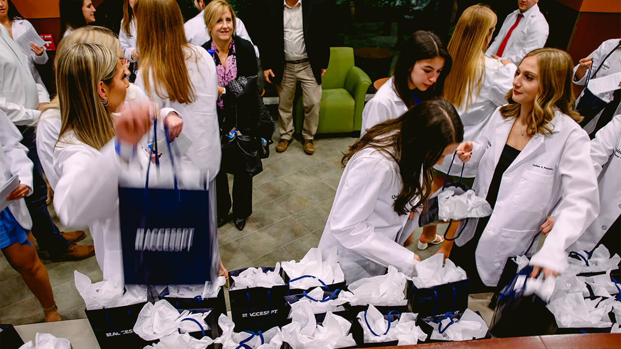 Students grabbing goodie bags after the DPT White Coat Ceremony
